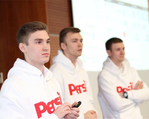 Drie Henkel werknemers dragen een Persil sweater en presenteren. 