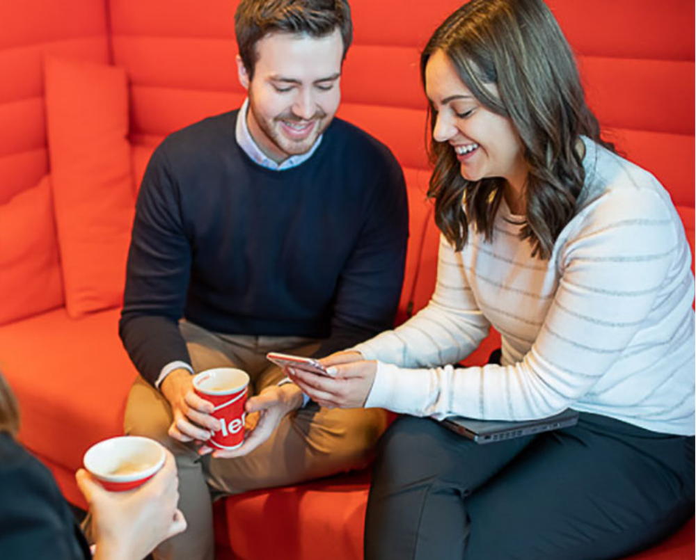 Drie Henkel werknemers drinken koffie en praten. 