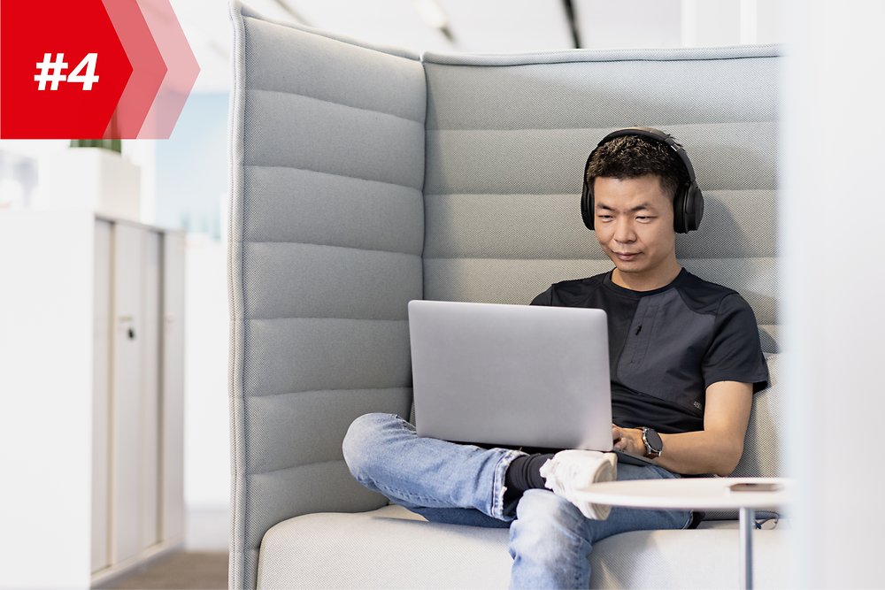 Henkel werknemer Hao, Hoofd van Mobile App Factory, met hoofdtelefoon en zijn laptop.